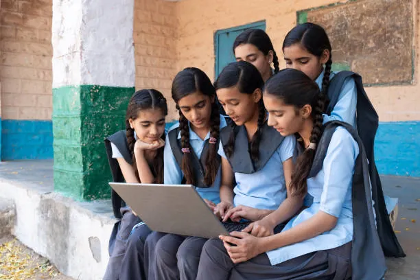 Indian schoolgirls learning together with a laptop
